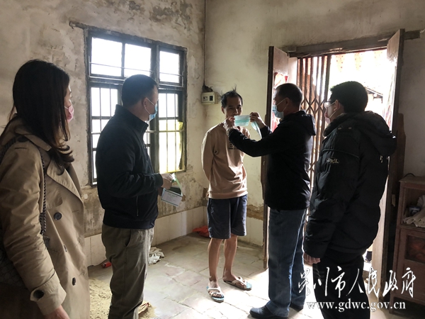梅嶺社區干部給精準扶貧戶何振福戴上口罩。2045.jpg