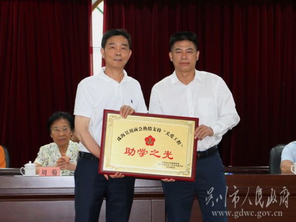 8-今年的30萬元助學金由珠海吳川商會資助。我市市委副書記、市長陳恩才（右）向珠海吳川商會授“助學之光”牌匾。IMG_2956.jpg